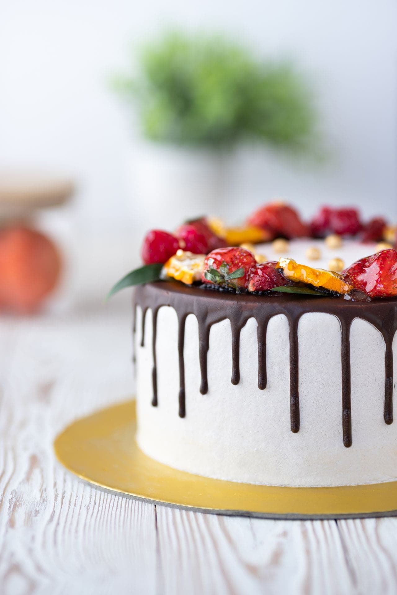 Festliche Torte mit Schokoladenglasur, frischen Beeren und Goldakzenten